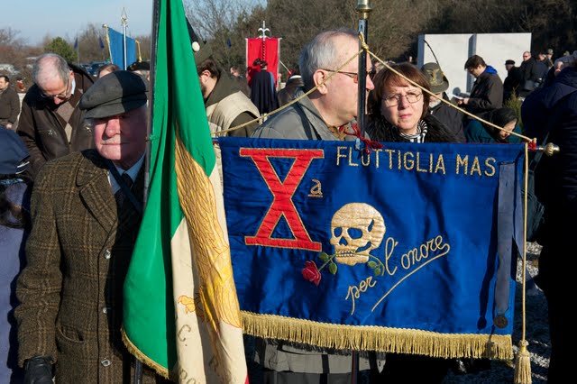 Basovizza, 10 febbraio 2011: labaro della X Mas, formazione collaborazionista responsabile di rastrellamenti e stragi. La fotografia è presa dal sito della Lega Nazionale di Trieste, dove è inclusa in una galleria di immagini di quella giornata, senza alcuna presa di distanza né commento. 